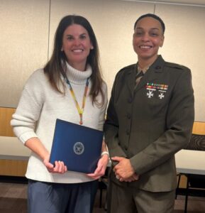 two women, one in military uniform and the other holding an award